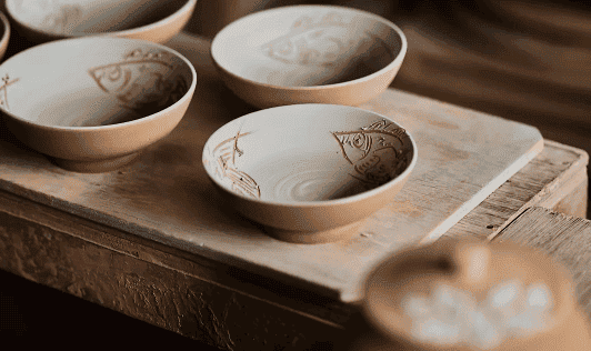 Tsuboya pottery bowls crafted by the Kinjo family, showcasing Okinawa’s ceramic traditions at Rosewood Miyakojima, blending cultural heritage with sustainable luxury.