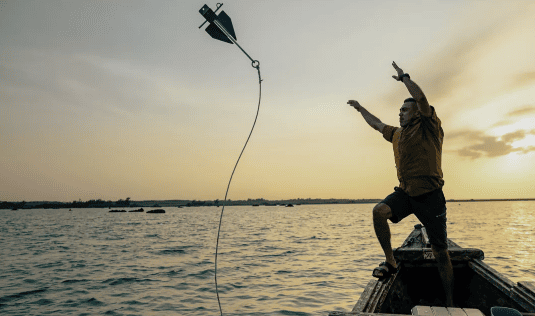 A serene scene of traditional Okinawan spearfishing in Miyakojima's crystal-clear waters, guided by local fisherfolk. The image represents marine conservation, cultural heritage, and sustainable tourism aligned with Regenera Luxury's principles.