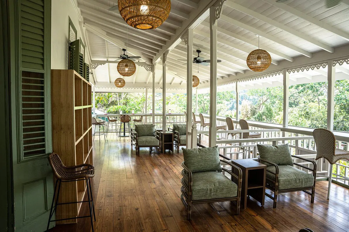 A beautifully designed boutique hotel exterior surrounded by greenery, showcasing an inviting entrance and sustainable architectural elements. The image reflects the REGENERA Boutique Hotel Assistance Initiative's focus on supporting small hotels through sustainable practices, eco-friendly operations, and enhanced guest engagement